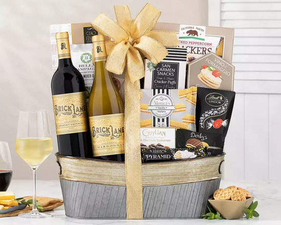 Gift basket with wine bottles, snacks, and a bow on a white surface. Gift basket with wine bottles, snacks, and a bow on a white surface.