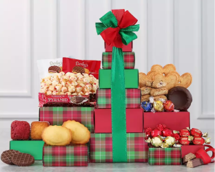 Decorative gift box with a large red bow, surrounded by various snacks and treats