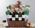 Wine gift basket with bottles, snacks, and a bow on a white background