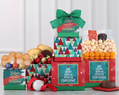 Stack of Christmas-themed gift boxes with festive snacks