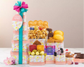 Stacked gift tower with various treats and a colorful ribbon on a neutral background