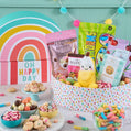 Assorted snacks and candies in a colorful box with 'Oh Happy Day' branding