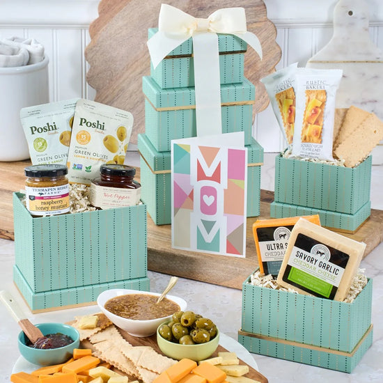 Gift basket with snacks and a 'Mom' card on a table.