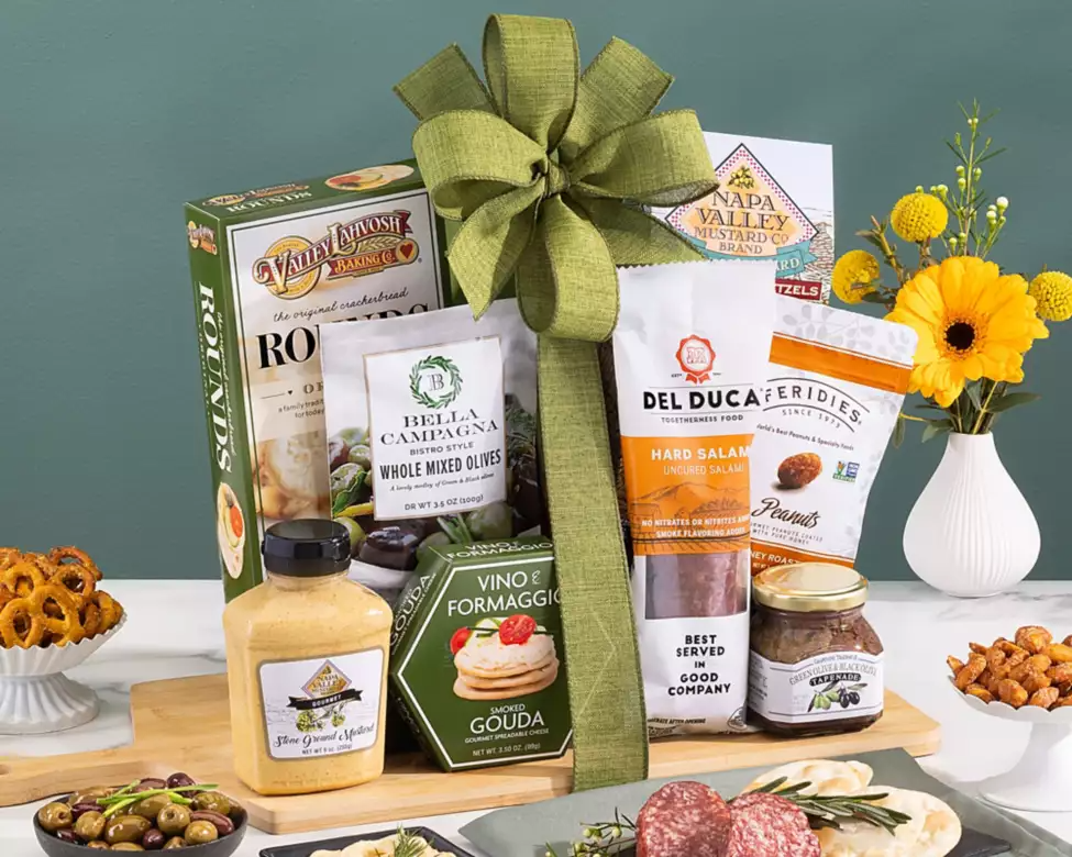 Gift basket with Del Luca products, cheese, and snacks on a cutting board  
